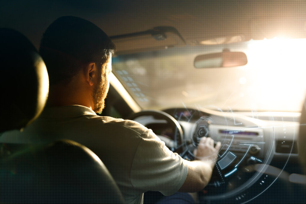 Man driving a car while touching a virtual screen.