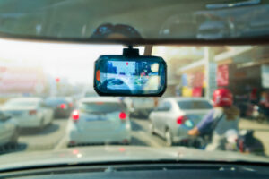 Dashcam inside a car recording vehicles and buildings along the highway.