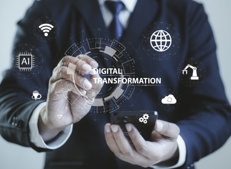 Businessman holding a smartphone while pointing to digital transportation icons on a virtual screen.