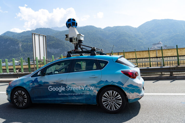 Blue Google Street View car on the road.