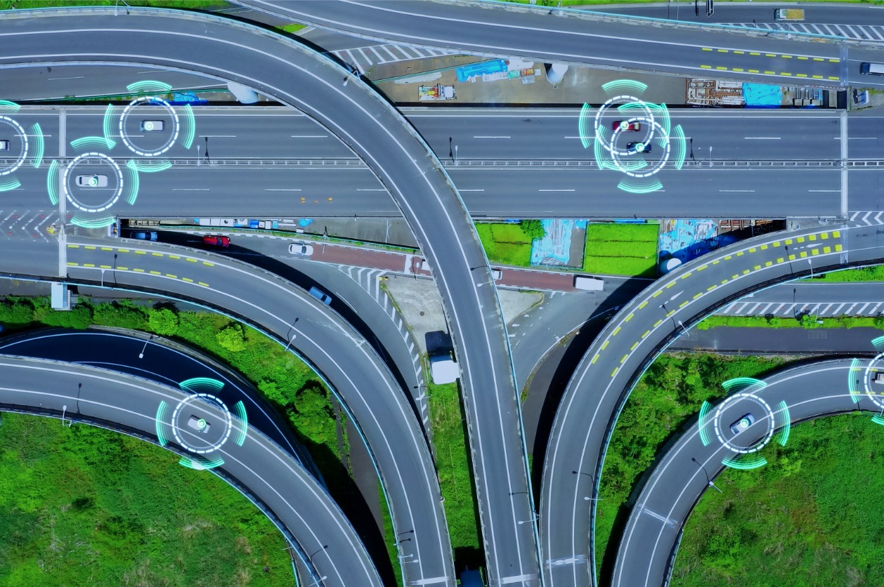 Highway Performance Monitoring System Modernization - An aerial view of a national highway showing vehicles and roadways analyzed by AI.