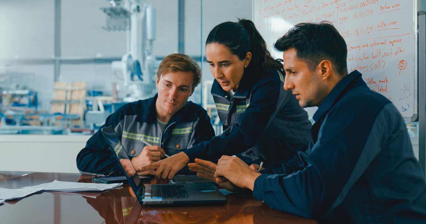 A group of engineers collaborating and analyzing data on a laptop using AI-powered imagery intelligence.