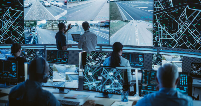 Digital Twins for Road Networks: A big group of people in front of big computer screens monitoring roads.