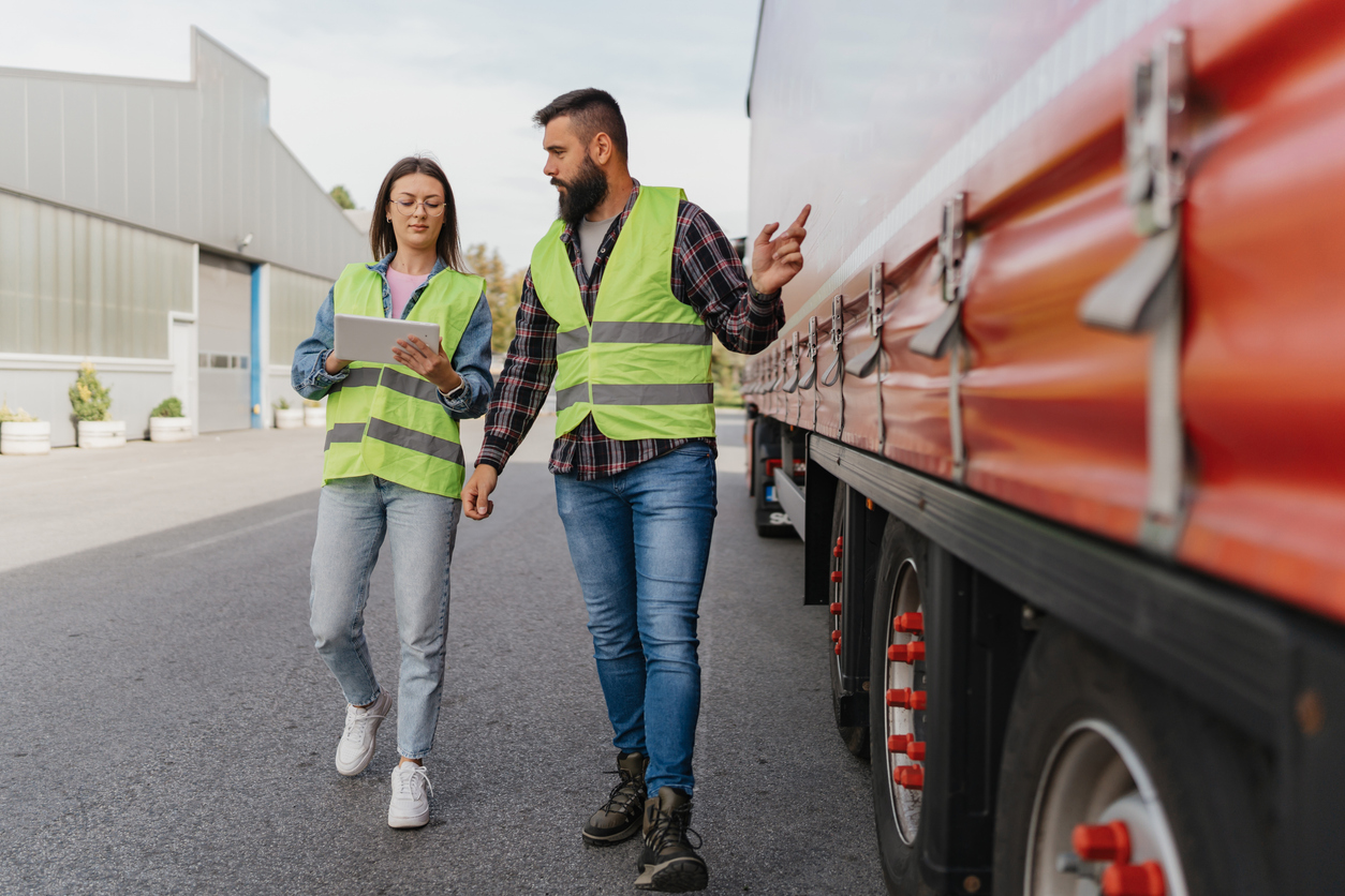 Mobile sensor network - Two workers, male and female, walking beside a truck.